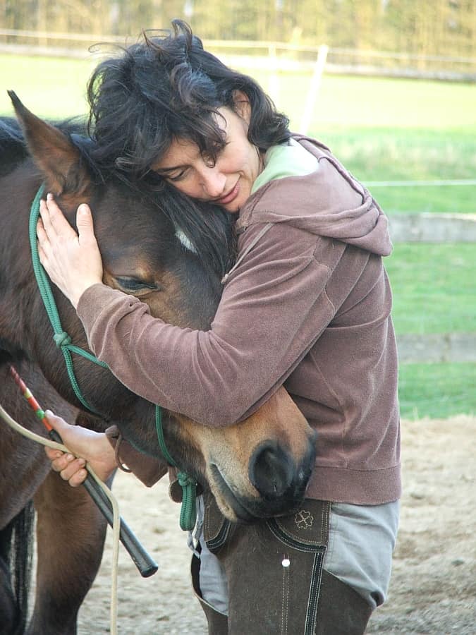 Marianne mit der braunen Stute Momo nachdem sie miteinander Natural Horsemanship am Boden geübt hatten. Tiergestützte Intervention und Natur-Mentoring verbindet Menschen und Tiere.