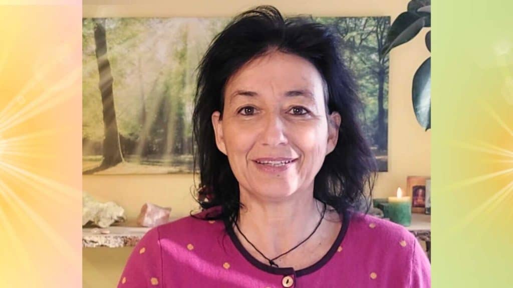 Marianne in ihrem Büro im Hintergrund ein strahlendes Waldbild