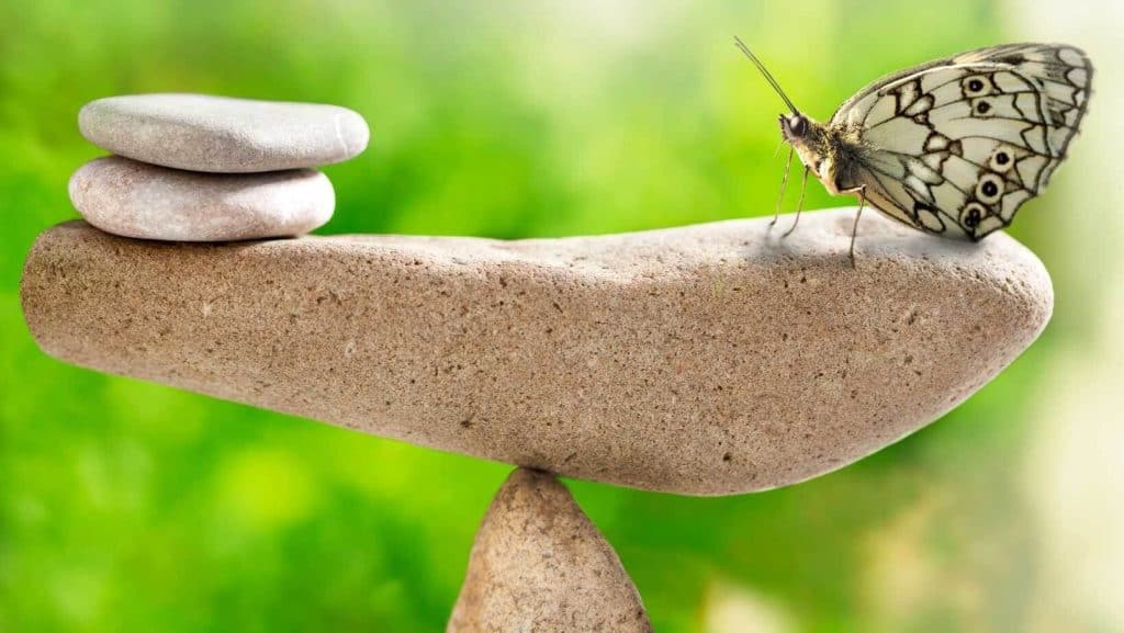 Es gibt viele Heilwege, die uns in Balance bringen können. Hier ein Steinturm auf dem ein Schmetterling sitzt und alles ist in Balance