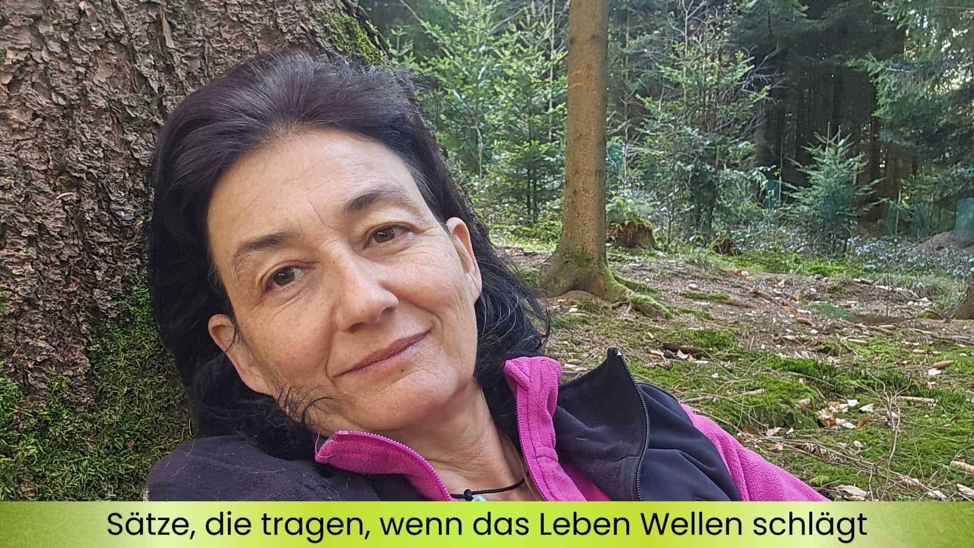Marianne am Waldboden angelehnt an einen Baum